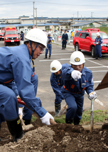 写真：10月4日に行われた町総合防災訓練。下田消防団第6分団の袴田喜代美副団長（右）の指示を受け、土砂を取り除く中村喜美男団員（左）