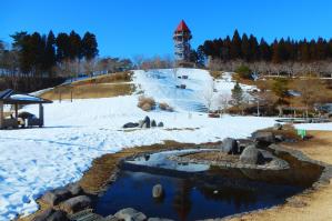 青空と芝生の積雪に挟まれた展望台の様子