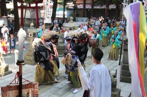 八幡宮境内で獅子舞が披露されている様子の写真です。