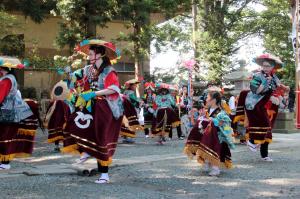 八幡宮境内で円になって駒踊りが行われている写真です。