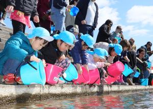 稚魚を放流する子どもたち