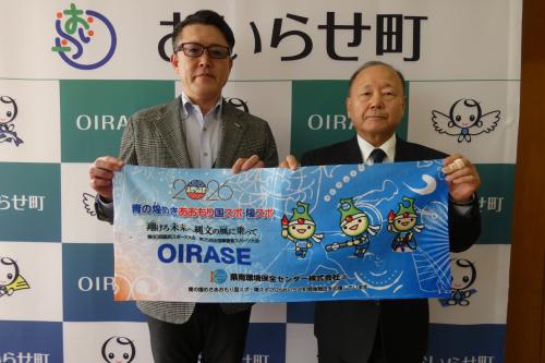 協賛品のタオルを手にする佐藤正樹代表取締役と松林教育長